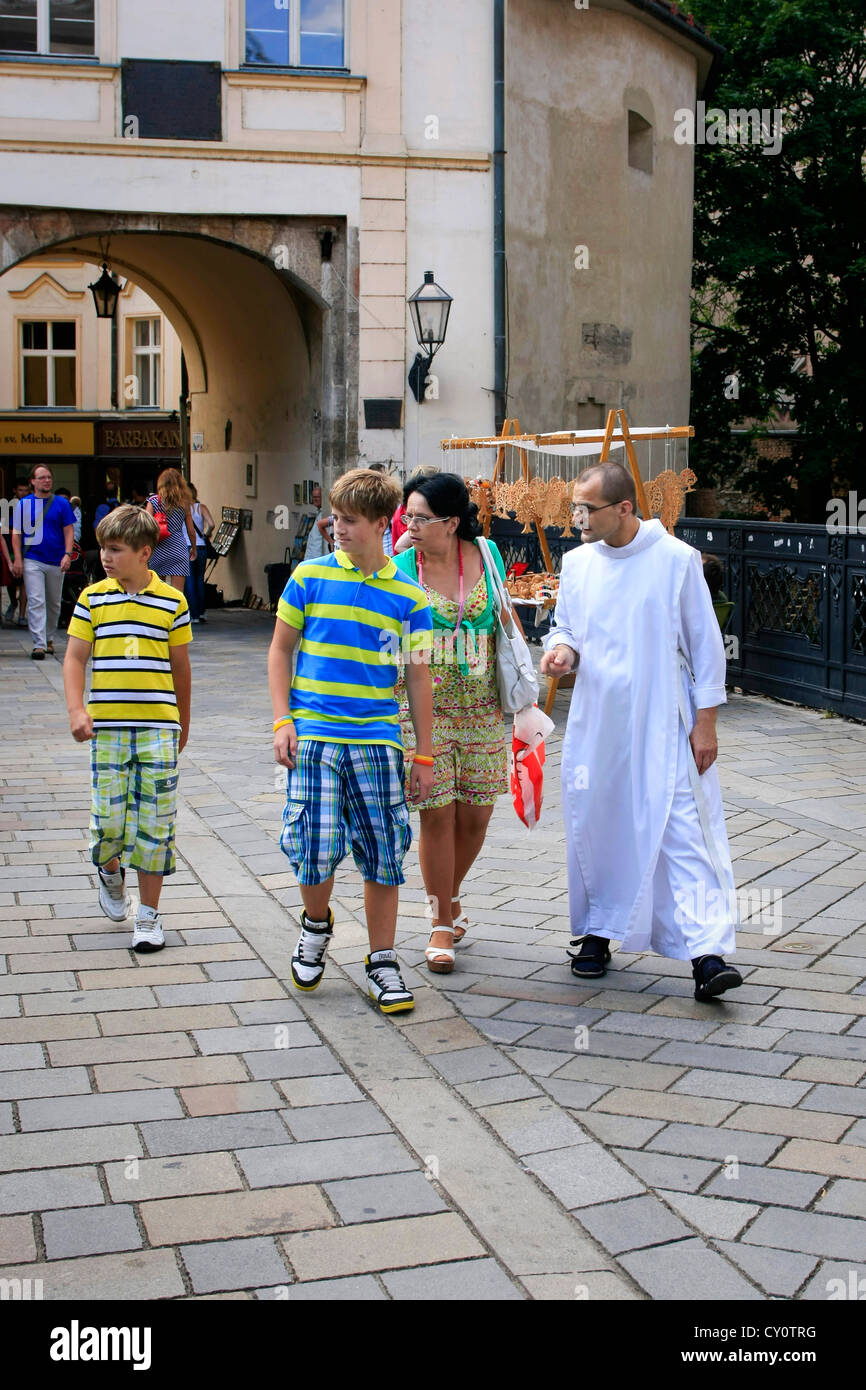 I turisti essendo guidata intorno al centro storico di Bratislava da un monaco in bianche vesti Foto Stock