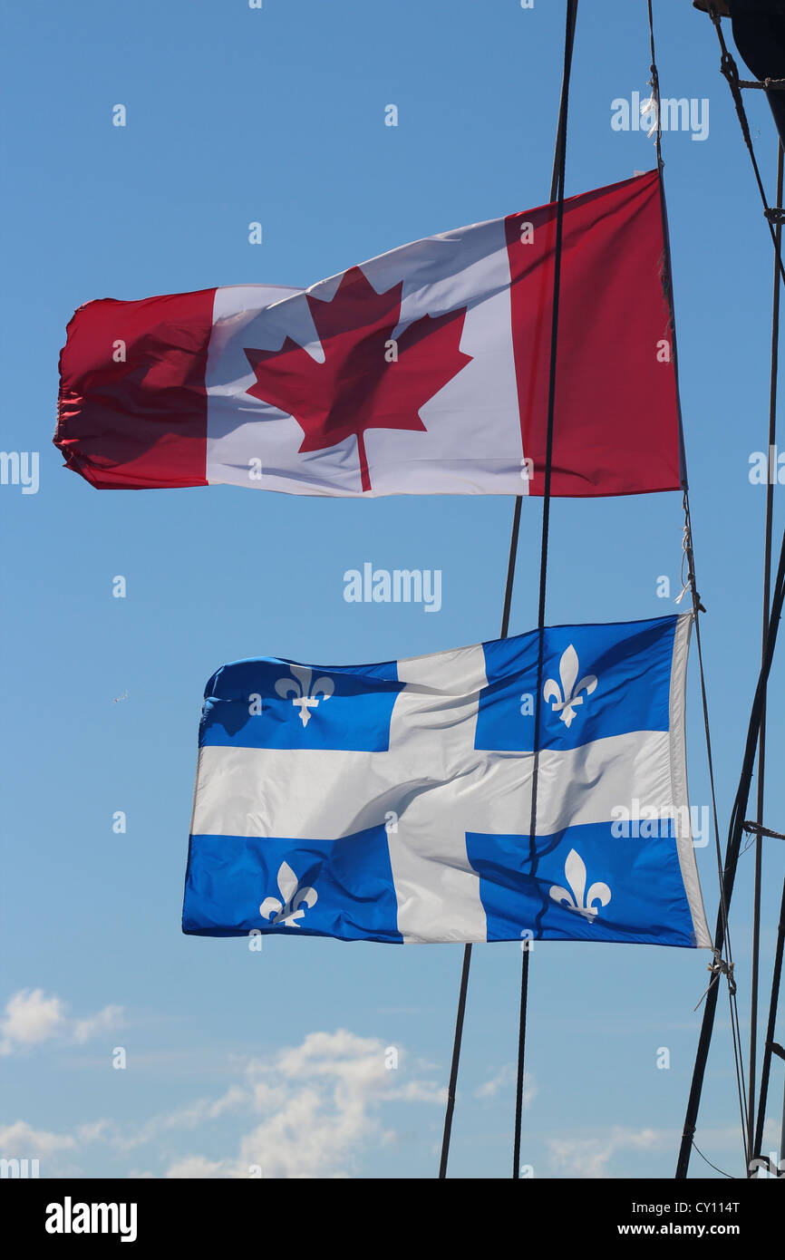 Canada e Quebec bandiera al vento, cielo blu Foto Stock