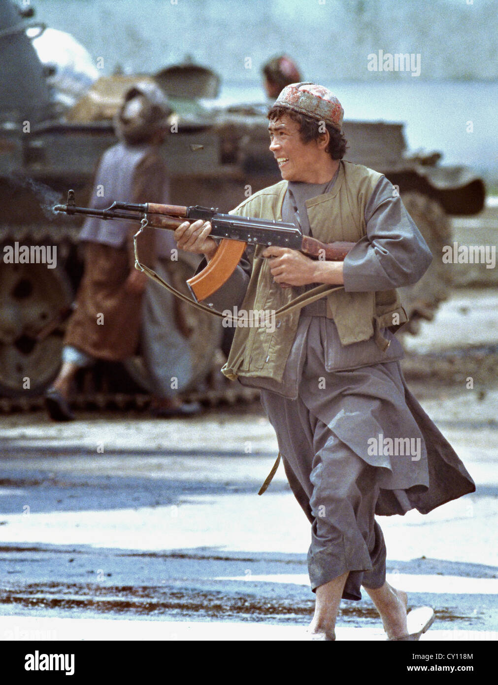 Un Afghan mujahideen fighter incendi il suo AK-47 durante la Lotta da strada come guerra civile scoppia nella capitale Kabul In seguito alla liberazione dal governo comunista Aprile 20, 1992. Foto Stock