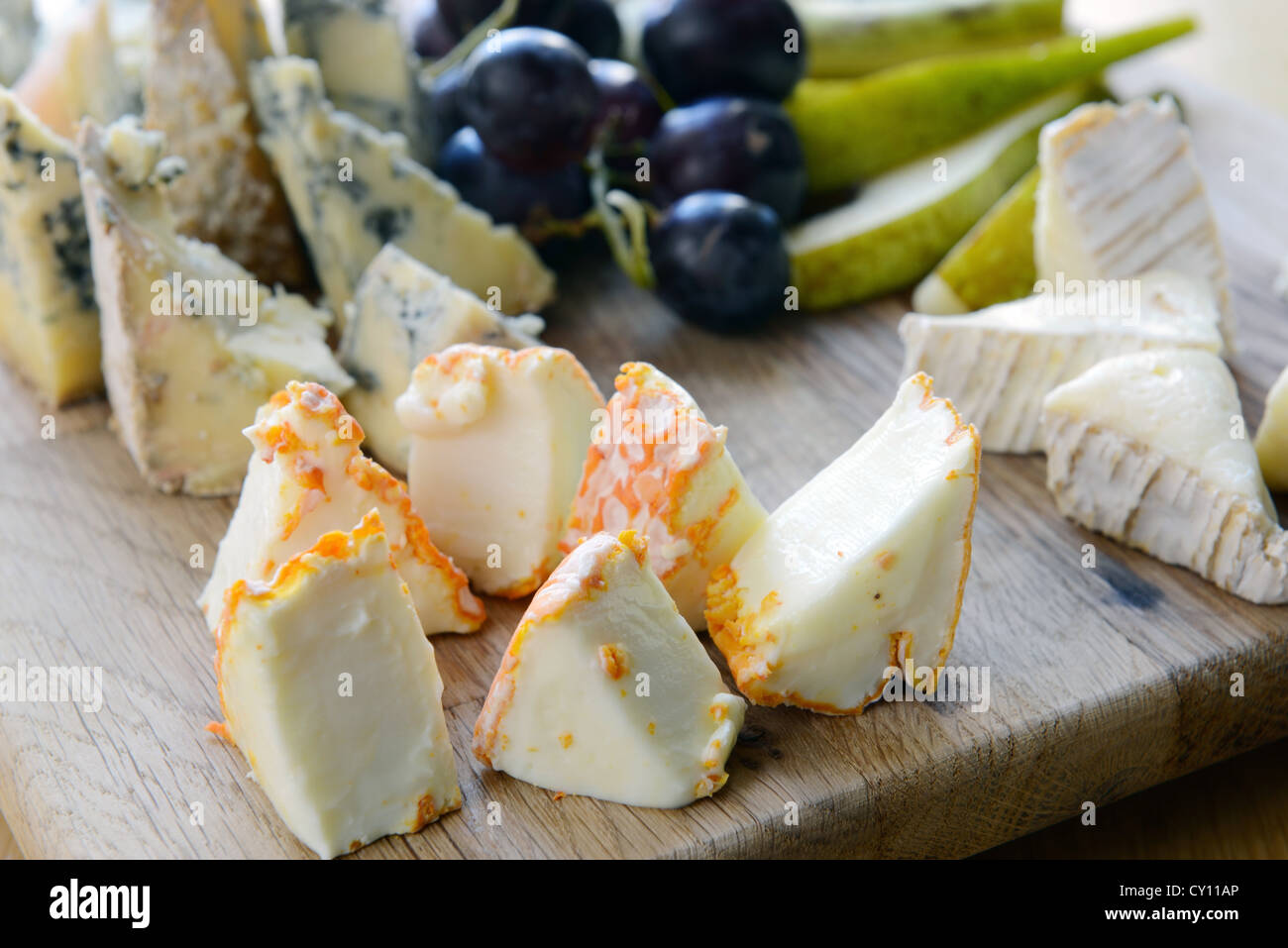 Set di formaggio con stampo su una tavola di legno con uva e pere Foto Stock