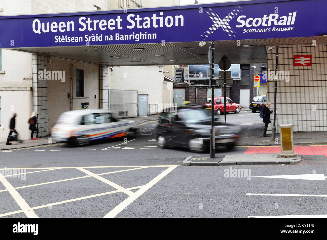 Stazione di Queen Street con taxi e pedoni sfocati in movimento che arrivano e vanno su North Hanover Street nel centro di Glasgow, Scozia, Regno Unito Foto Stock
