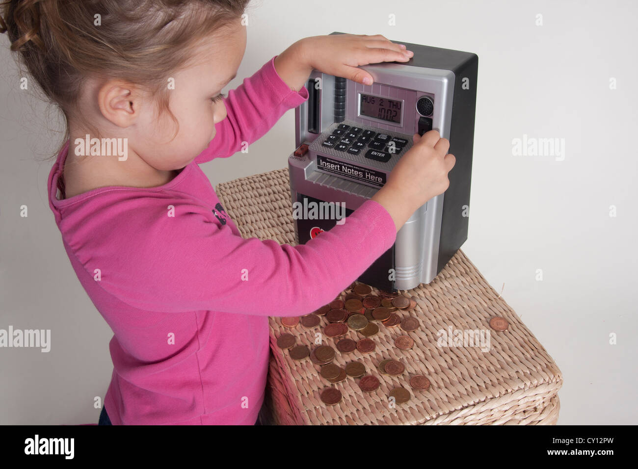 Bambina gioca sul giocattolo di registratore di cassa Foto Stock