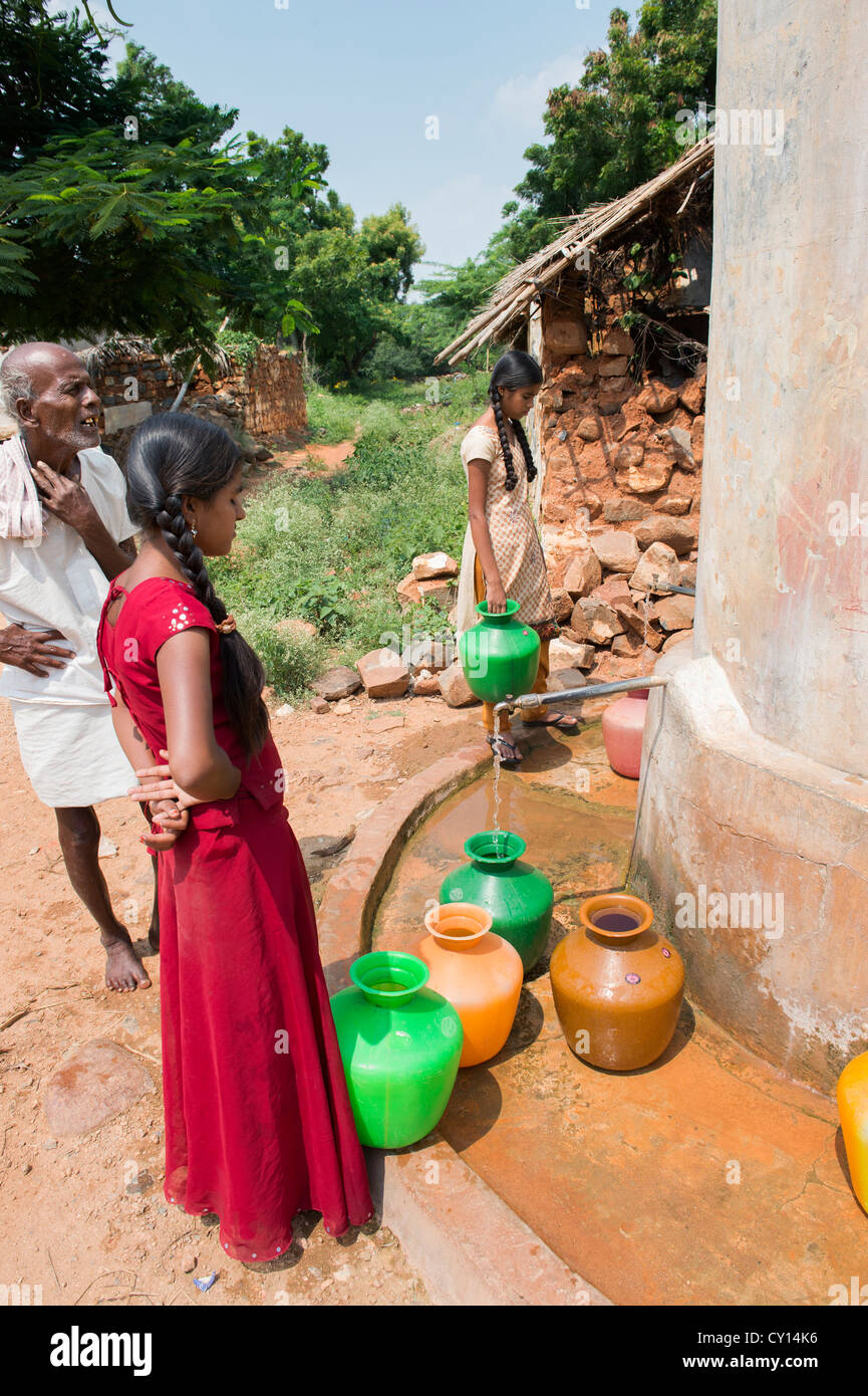 Rurale villaggio indiano ragazze raccolta di acqua da un comune serbatoio di acqua. Andhra Pradesh, India Foto Stock