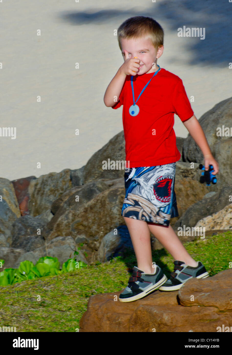 A cinque-anno-vecchio ragazzo con autismo dà una rara "Thumbs up' alla fotocamera. Foto Stock