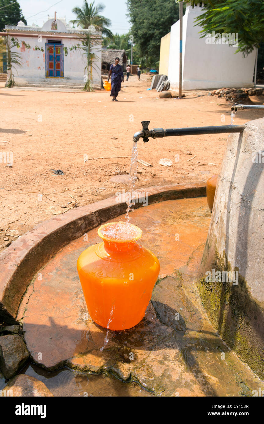 Rurale villaggio indiano donna raccolta di acqua da un comune serbatoio di acqua. Andhra Pradesh, India Foto Stock
