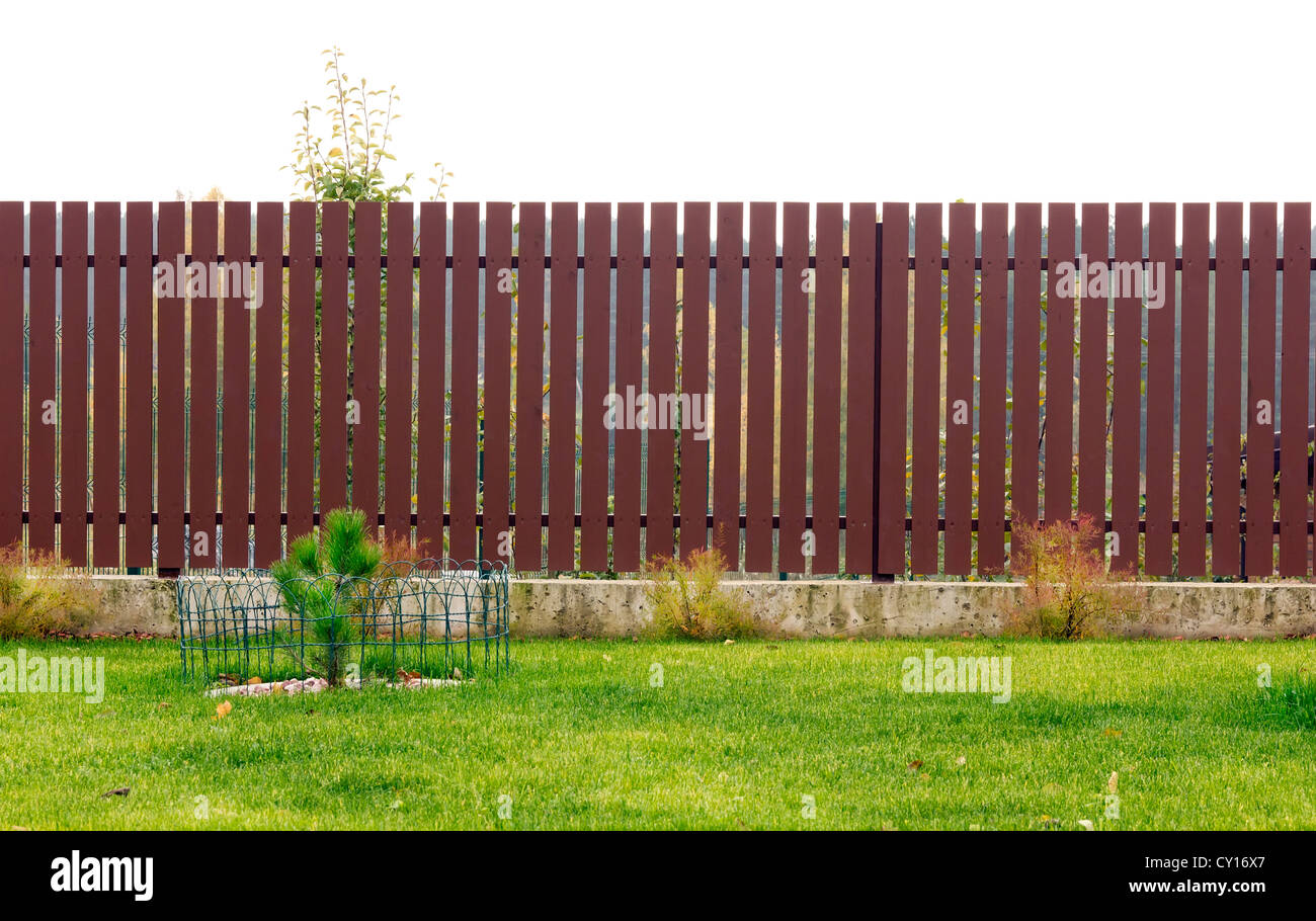 Rurali isolate marrone in legno recinto vicino a prato. Cloudly giorni di autunno Foto Stock