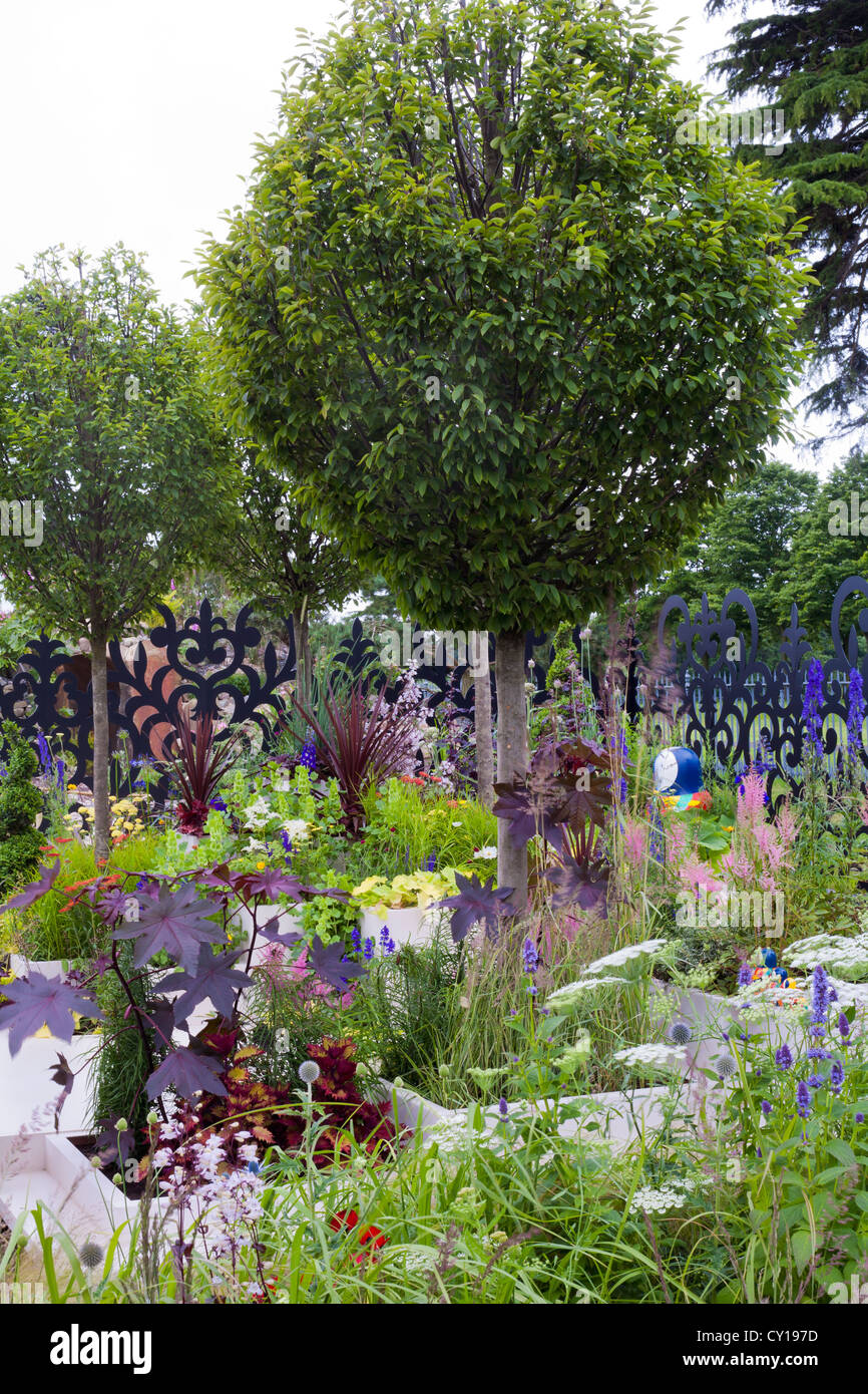 Vista del giardino contemporaneo con Carpinus betulus - carpino bianco come un punto focale. Foto Stock