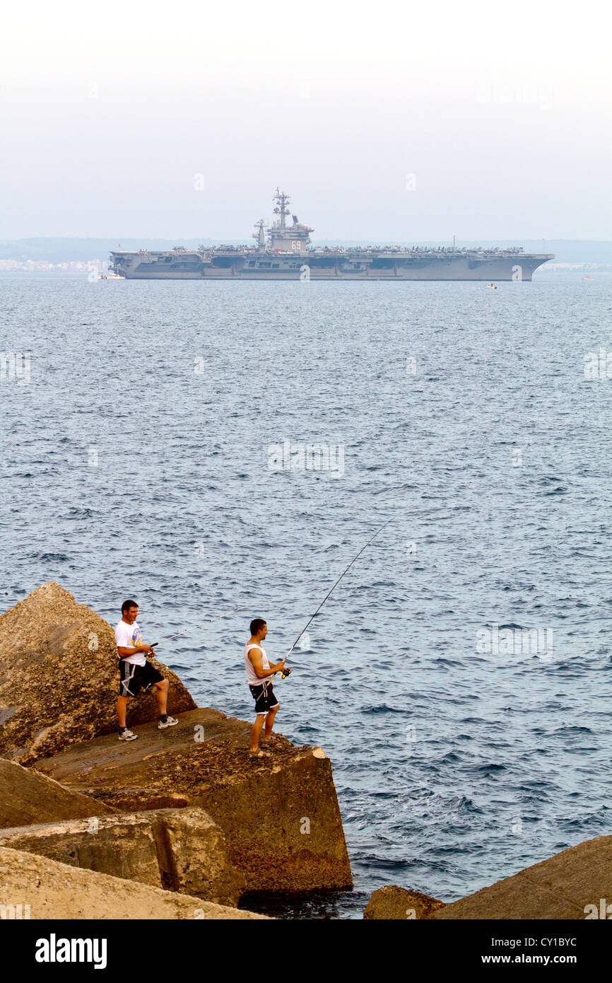 I pescatori e la portaerei USS Dwight D. Eisenhower sull orizzonte (CVN-69) Palma de Maiorca Isole Baleari Spagna Foto Stock