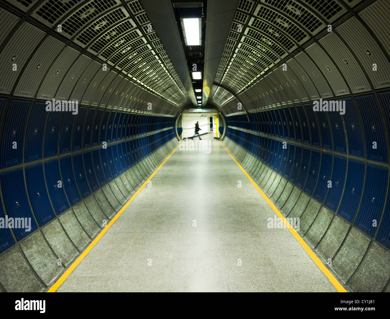 Moderno tunnel sotterraneo con lone figura attraversando a piedi di distanza Foto Stock