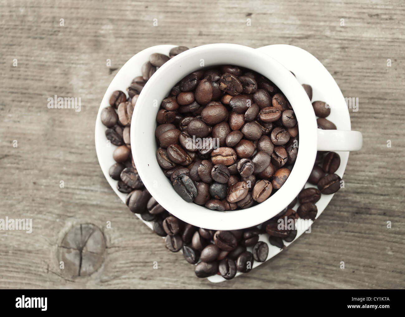 I chicchi di caffè in una tazza sul vecchio tavolato in legno Foto Stock