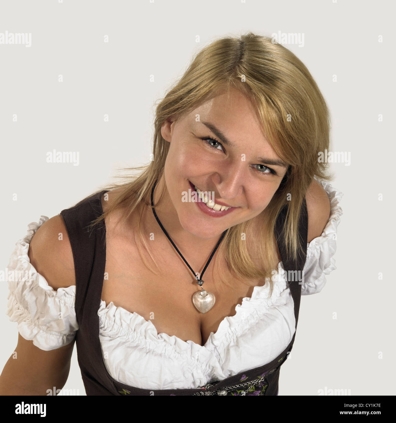 Sorridente donna bionda che indossa un abito tradizionale denominato dirndl Foto Stock