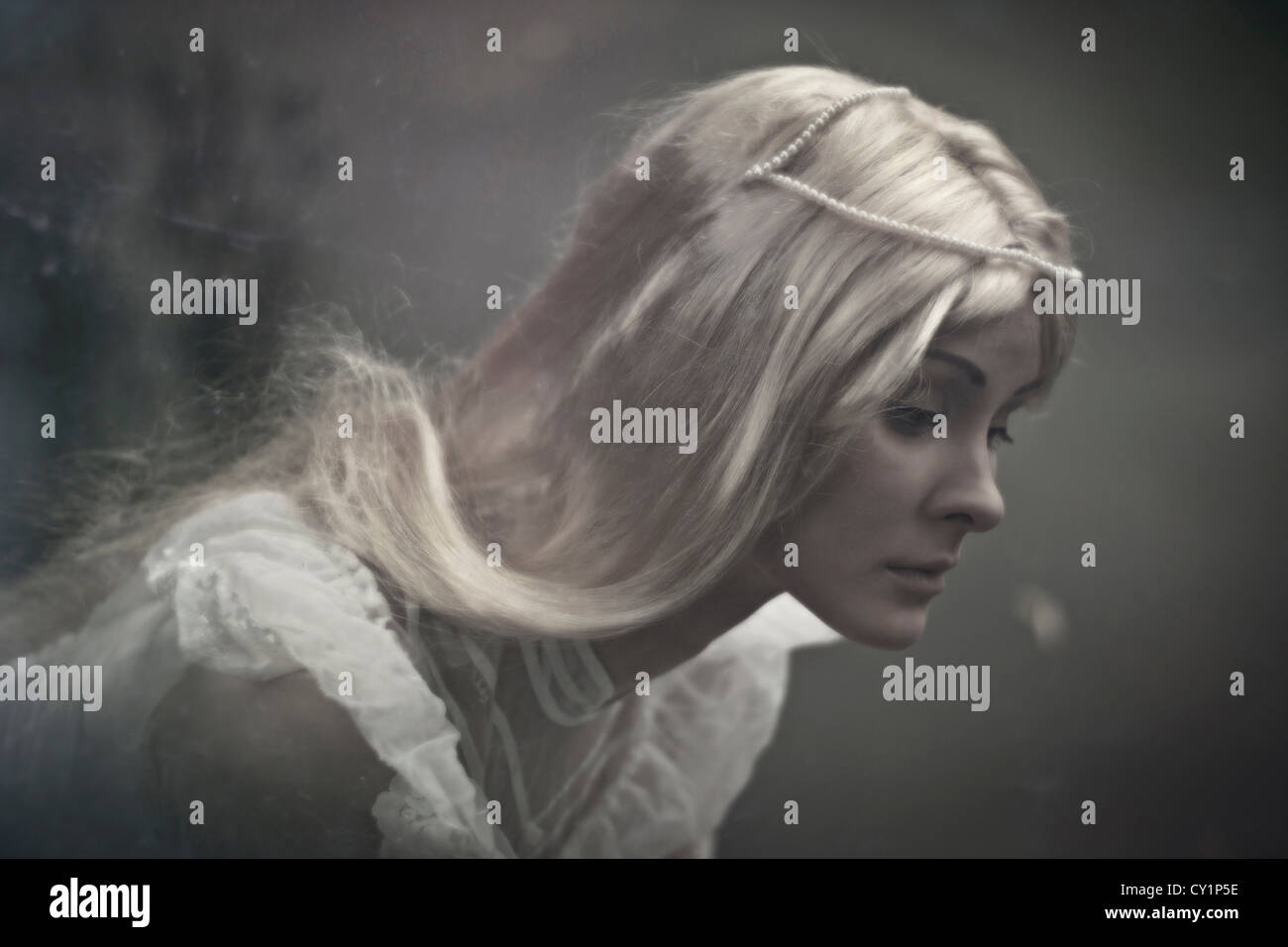 Una capigliatura bionda signora con big blue triste occhi per guardare con triste emozione indossando abito bianco Foto Stock