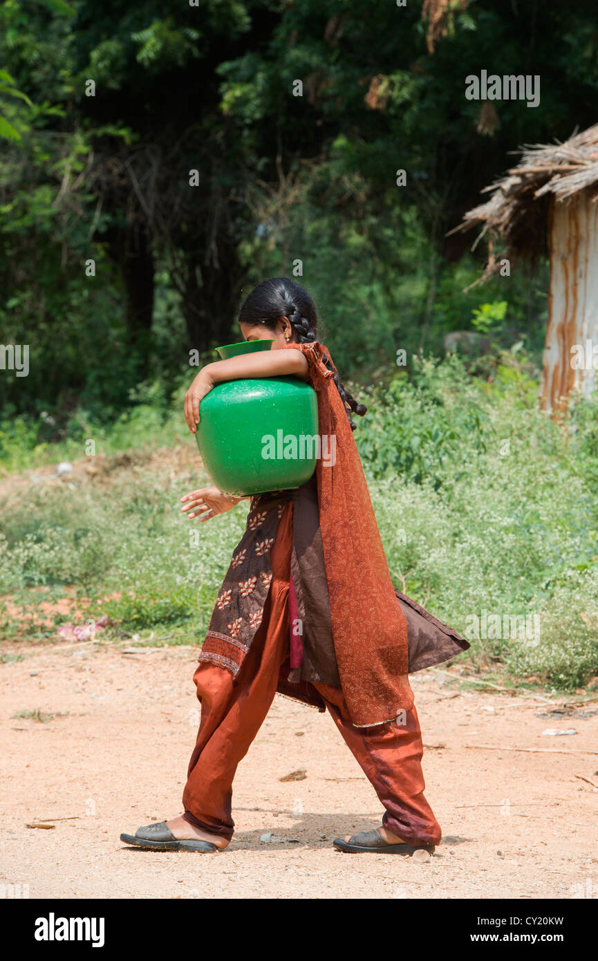 Rurale villaggio indiano ragazza raccolta di acqua da un comune serbatoio di acqua. Andhra Pradesh, India Foto Stock