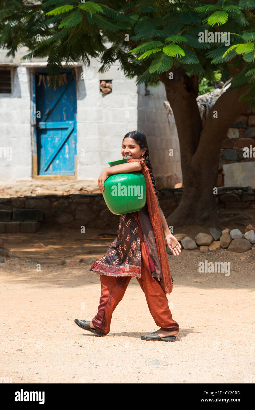 Rurale villaggio indiano ragazza raccolta di acqua da un comune serbatoio di acqua. Andhra Pradesh, India Foto Stock