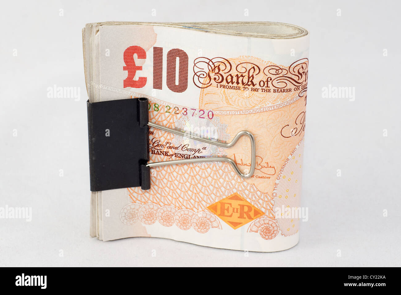 Un fascio di dieci British pound note tenute insieme con un bulldog clip Foto Stock