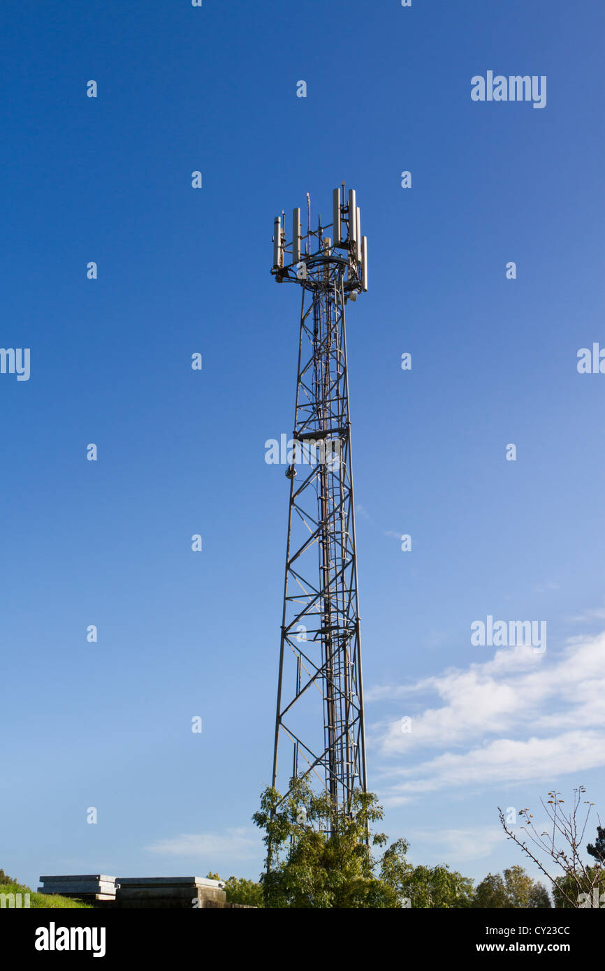 Il forno a microonde e comunicazioni di telefono mobile torre del relè e edifici ausiliari contro il cielo blu Foto Stock