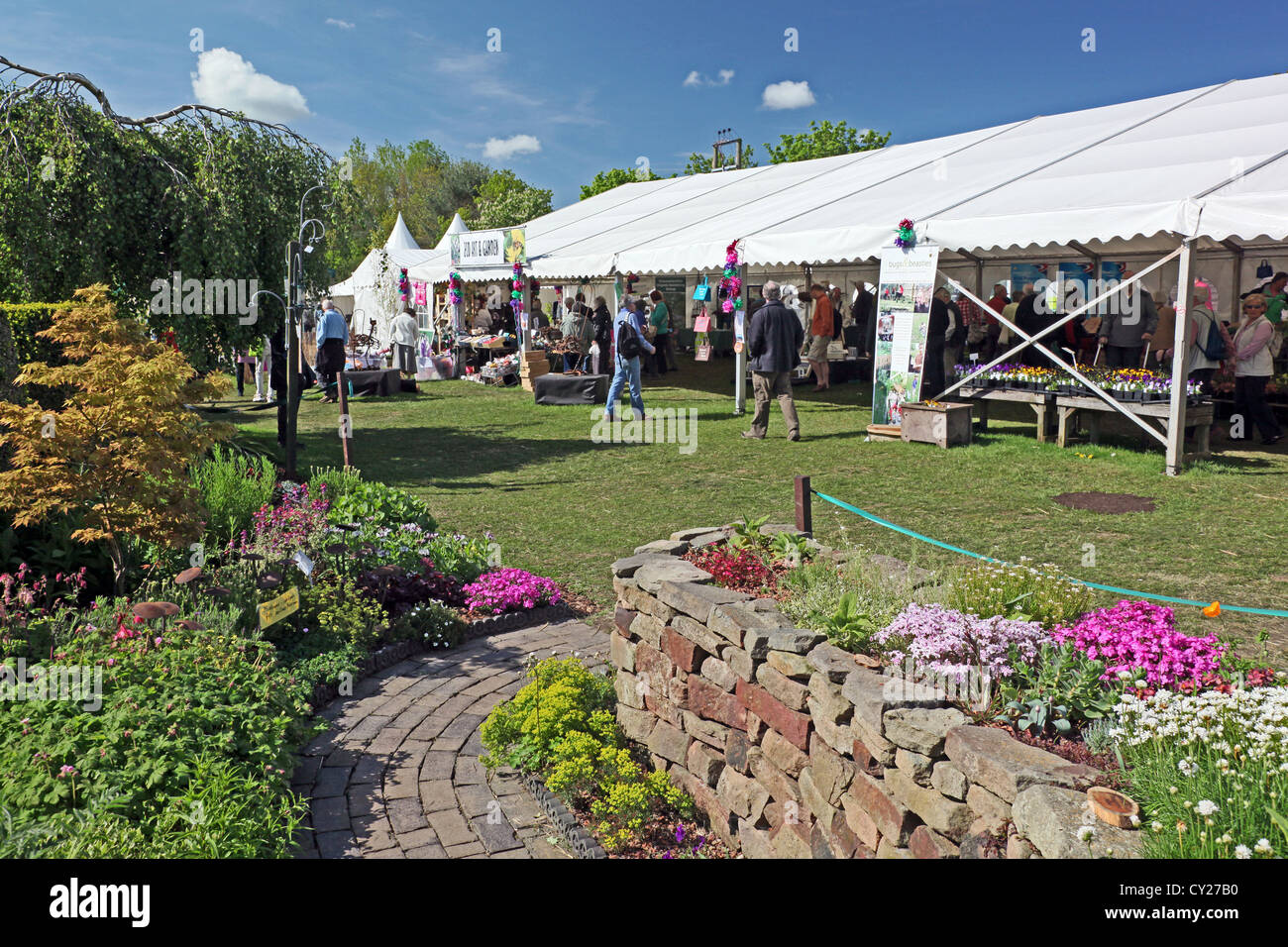 Uno dei molti giardini colorati e una tenda piena di stand commerciali della RHS Malvern Visualizza, Worcestershire, England, Regno Unito Foto Stock