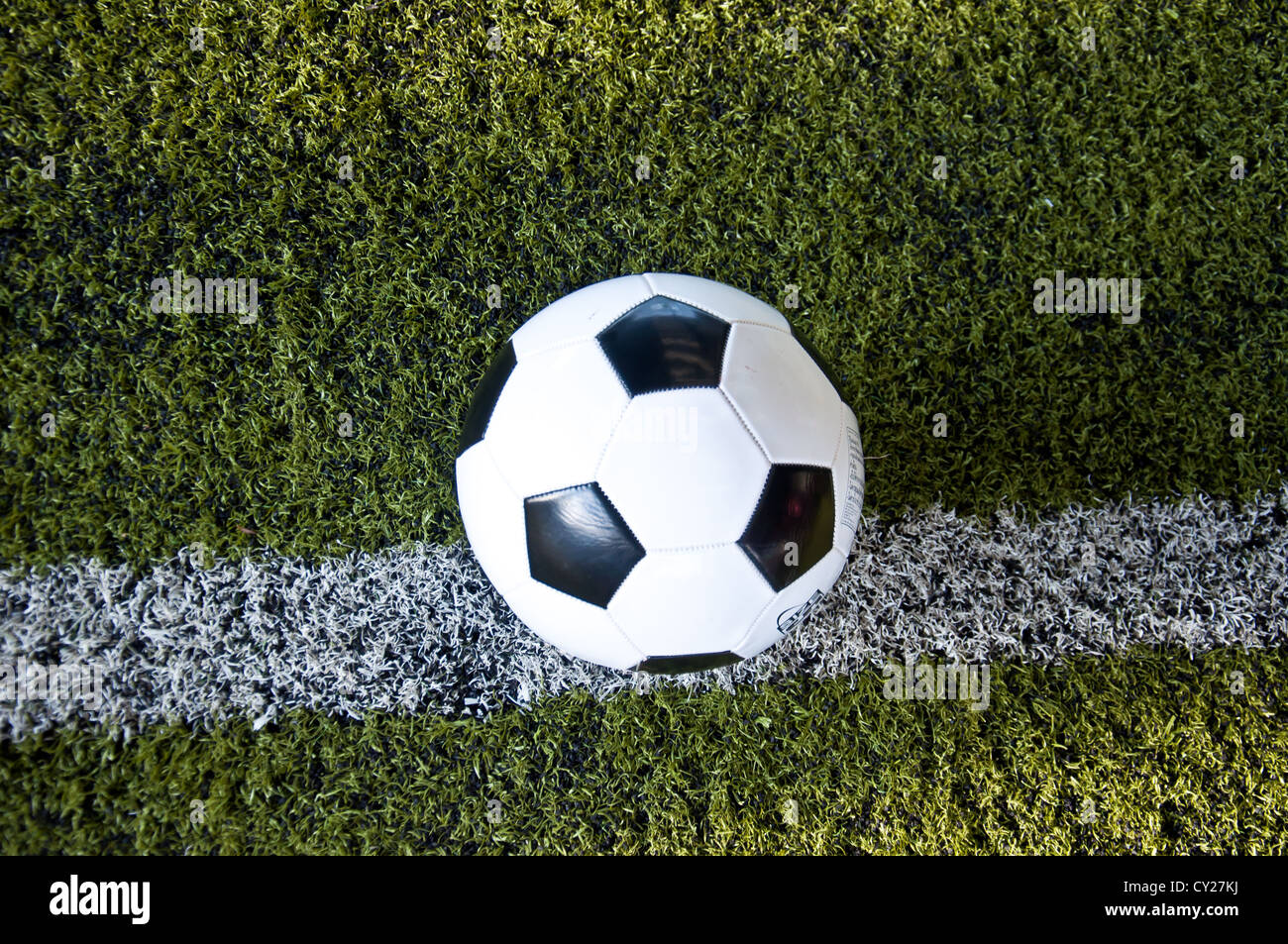 La sfera sulla linea bianca di erba artificiale al coperto campo da calcio Foto Stock