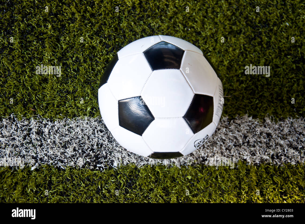 La sfera sulla linea bianca di erba artificiale al coperto campo da calcio Foto Stock