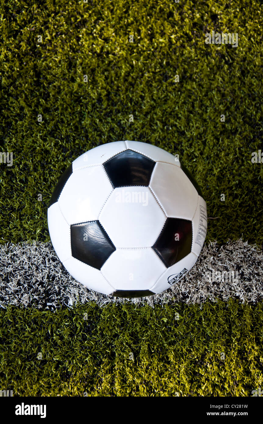 La sfera sulla linea bianca di erba artificiale al coperto campo da calcio Foto Stock