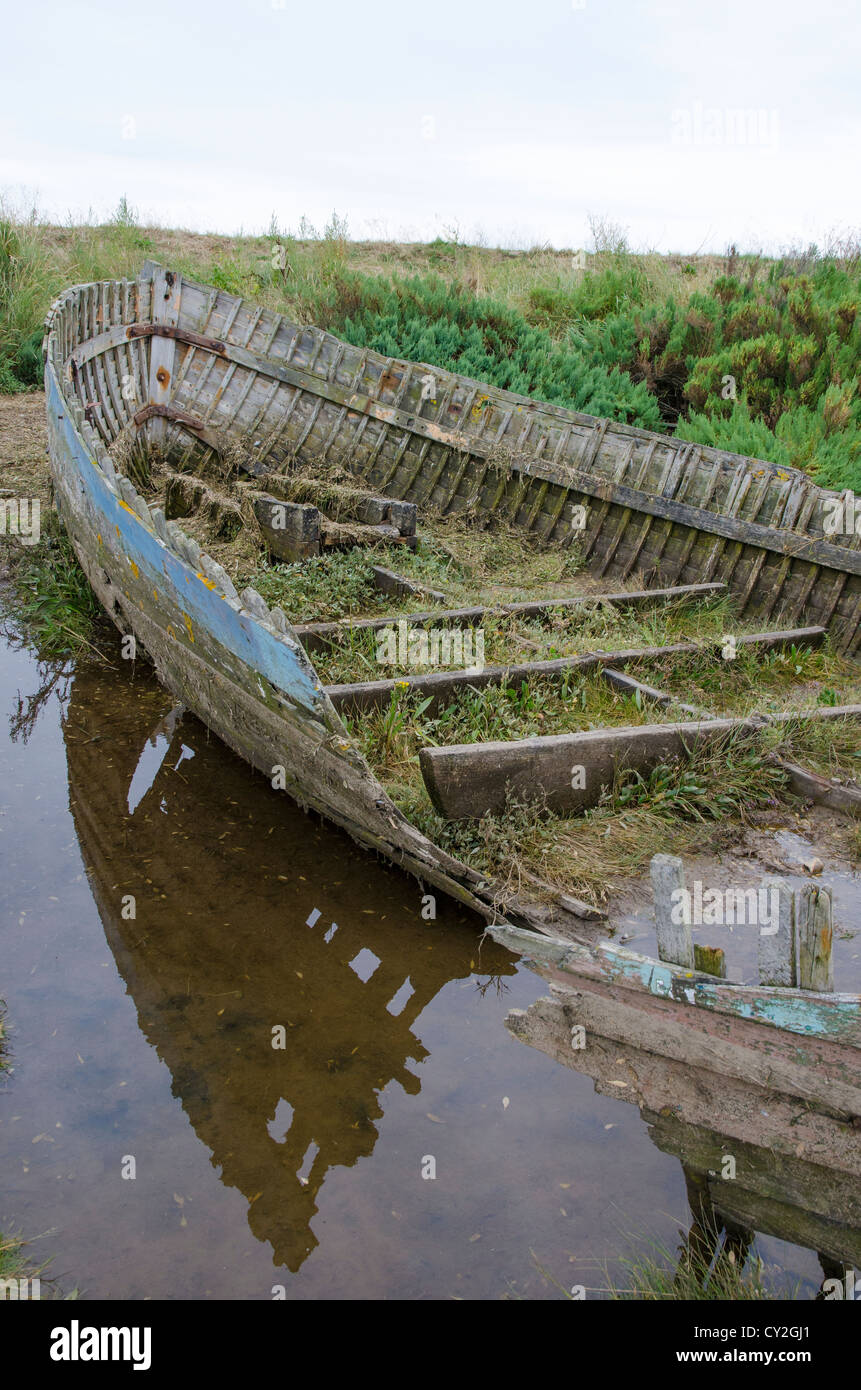 Relitto di clinker costruito la barca di legno, su saltmarsh costiere, North Norfolk, Inghilterra Foto Stock