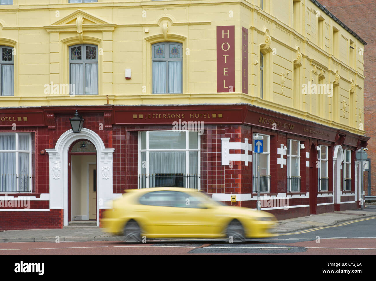 Giallo auto passando Jeffersons Hotel, Duke Street, Barrow-in-Furness, Cumbria, England Regno Unito Foto Stock