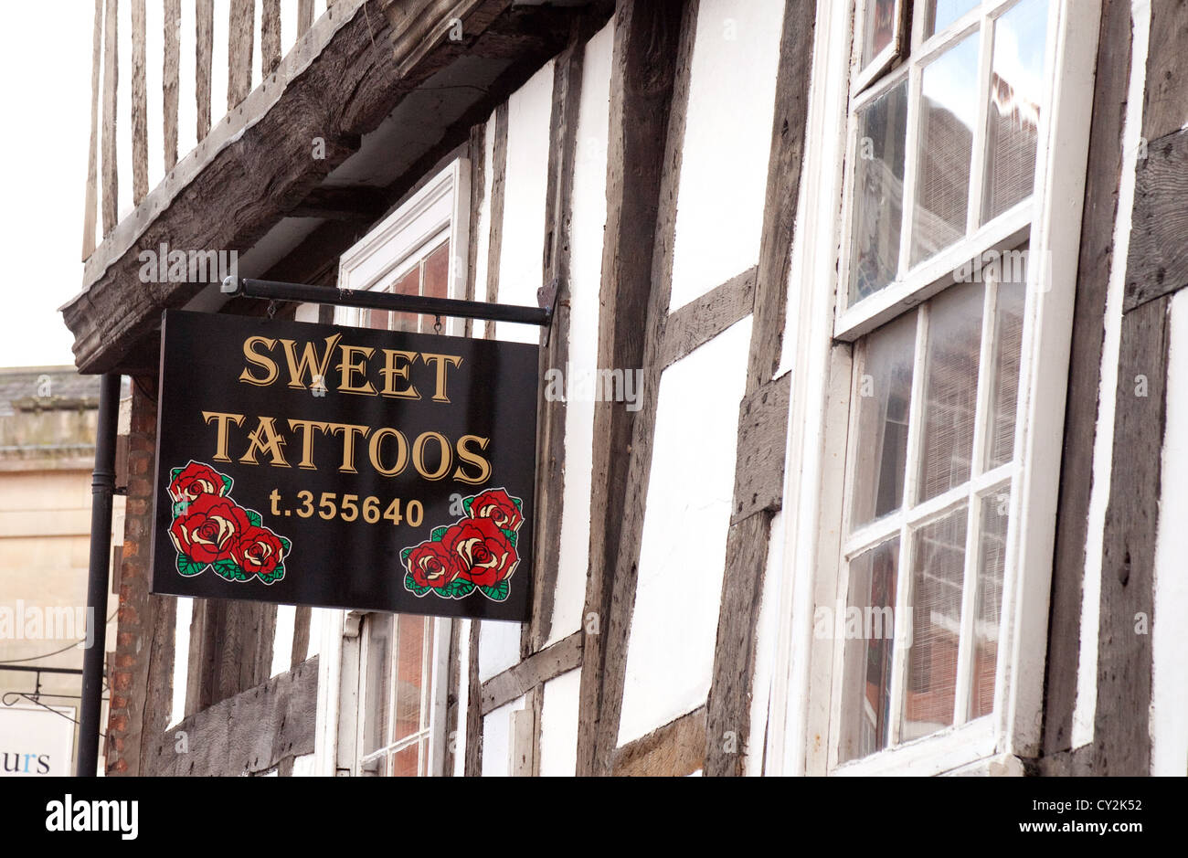 Salotto Tattoo segno su un graticcio edificio medievale, Shrewsbury nello Shropshire, Regno Unito Foto Stock