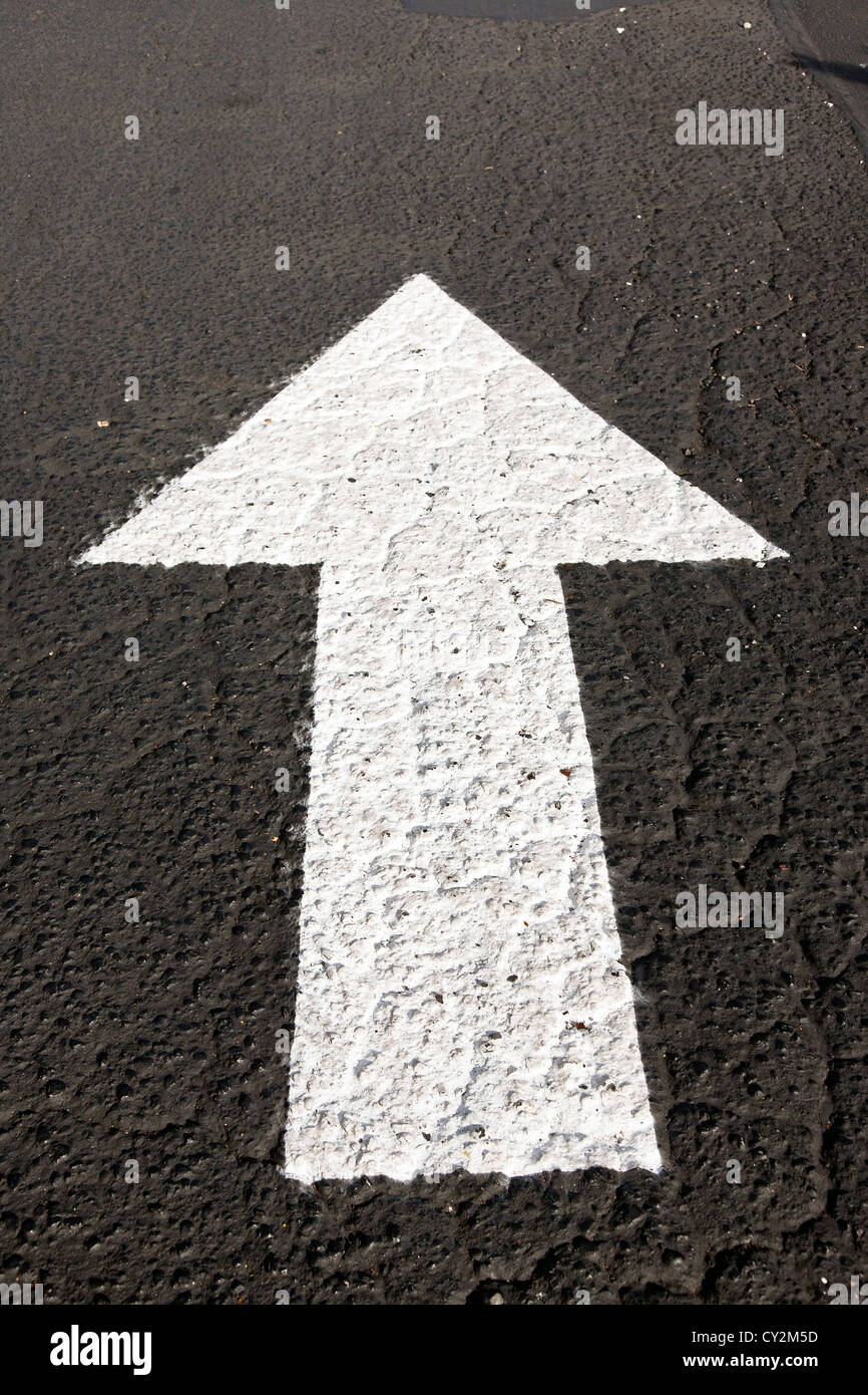 Dipinta di fresco iconico freccia bianca traffico marker direzionale su asfalto con pavimentazione a shopping mall parcheggio nello Stato di Washington Foto Stock