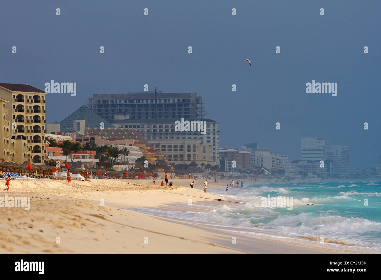 La spiaggia e il surf in Cancun Messico sotto uno scuro, cielo minaccioso Foto Stock