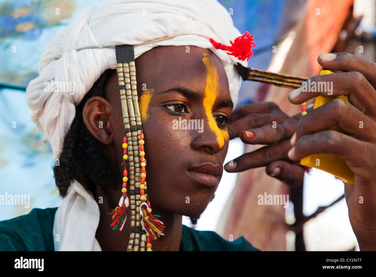 Wodaabe l uomo è messa su make up in preparazione per ballare in Ingal, Niger Foto Stock