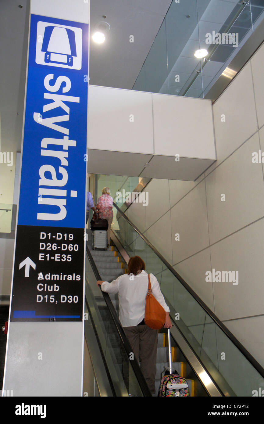 Miami Florida International Airport mia, Skytrain, cancello, trasporto, scala mobile, donna donna donna donna, bagagli, valigia, corrimano in mano, passeggero passenge Foto Stock