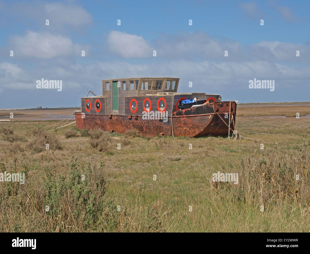 Vecchia draga sabbia viene convertito in una barca casa sulle barene a Blakeney Foto Stock