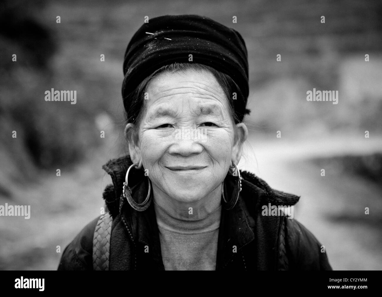 Sorridente vecchio nero Hmong donna con cappello tradizionale e orecchini, SAPA, Vietnam Foto Stock