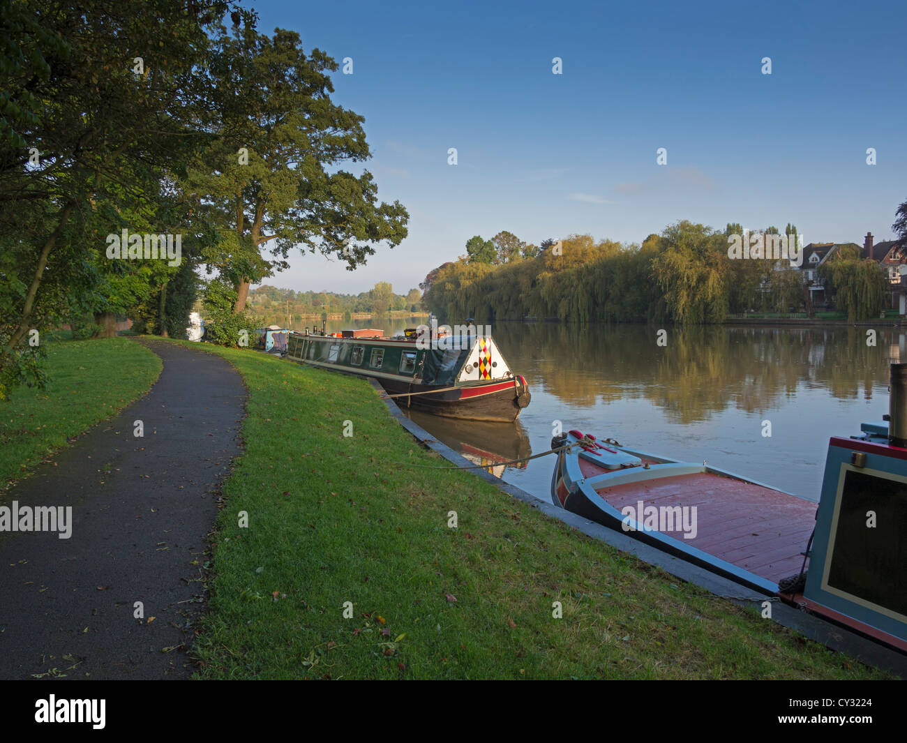 Narrowboats legata sul Fiume Tamigi a Cookham. Longboats tradizionali sono ormeggiati accanto a un sentiero su una mattina di autunno. Foto Stock