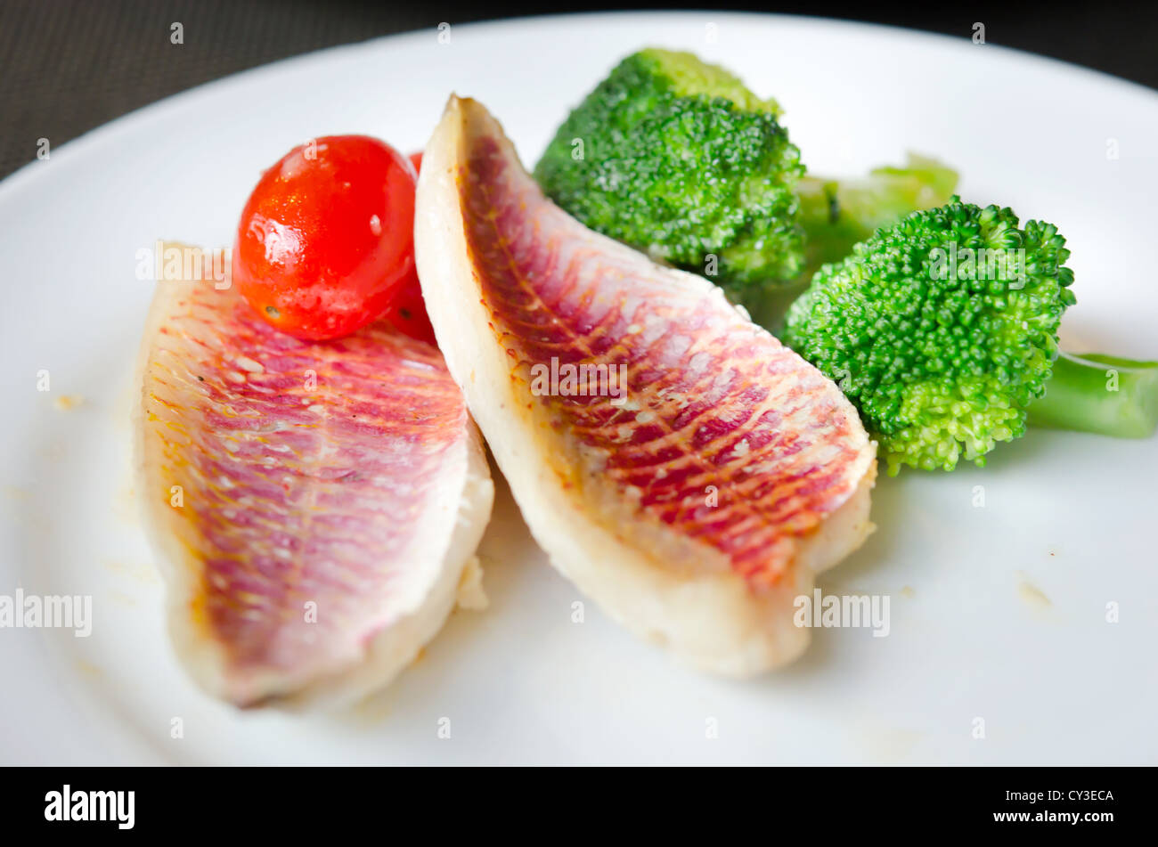 Grigliate di pesce con verdure fresche sul piatto bianco Foto Stock