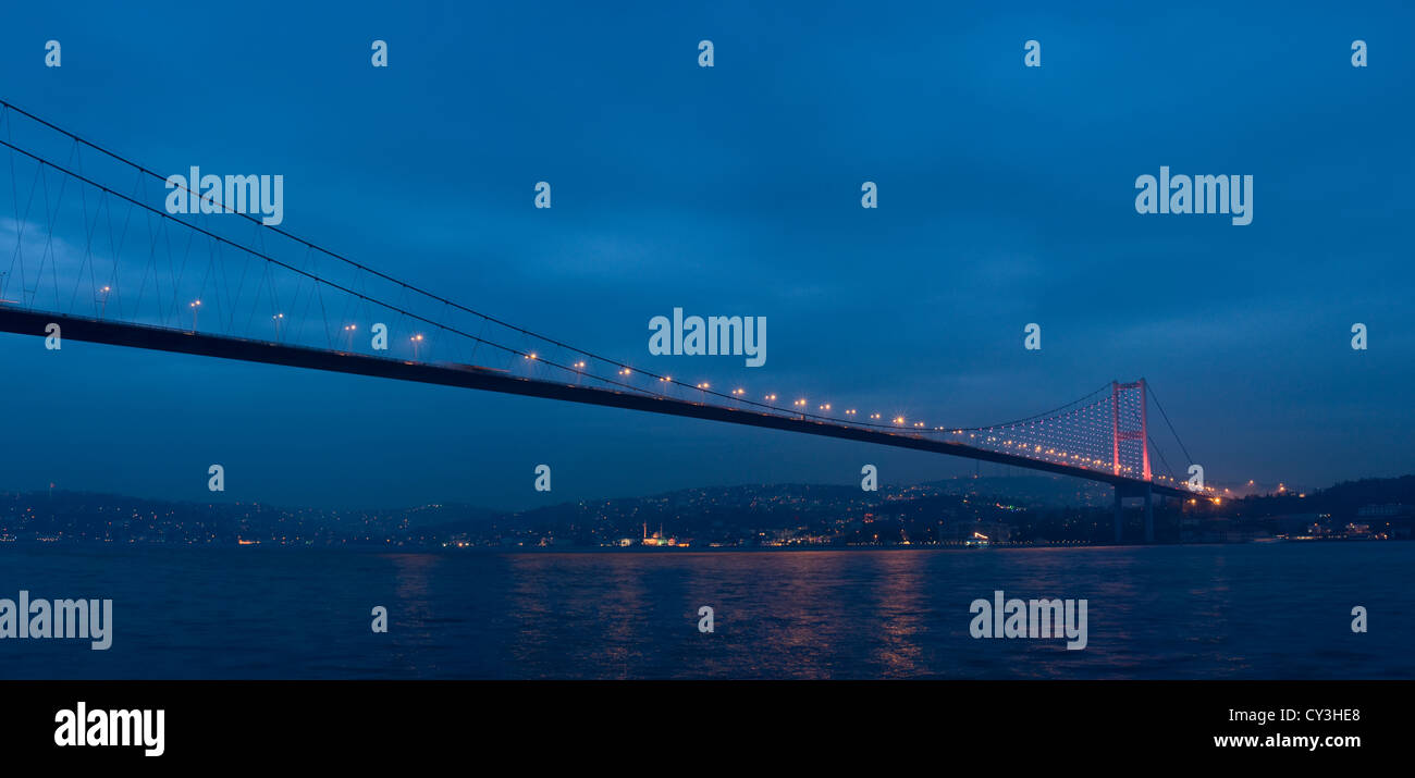 Primo ponte sul Bosforo (Boğaziçi Köprüsü) semi-illuminata di notte, Istanbul, Turchia Foto Stock