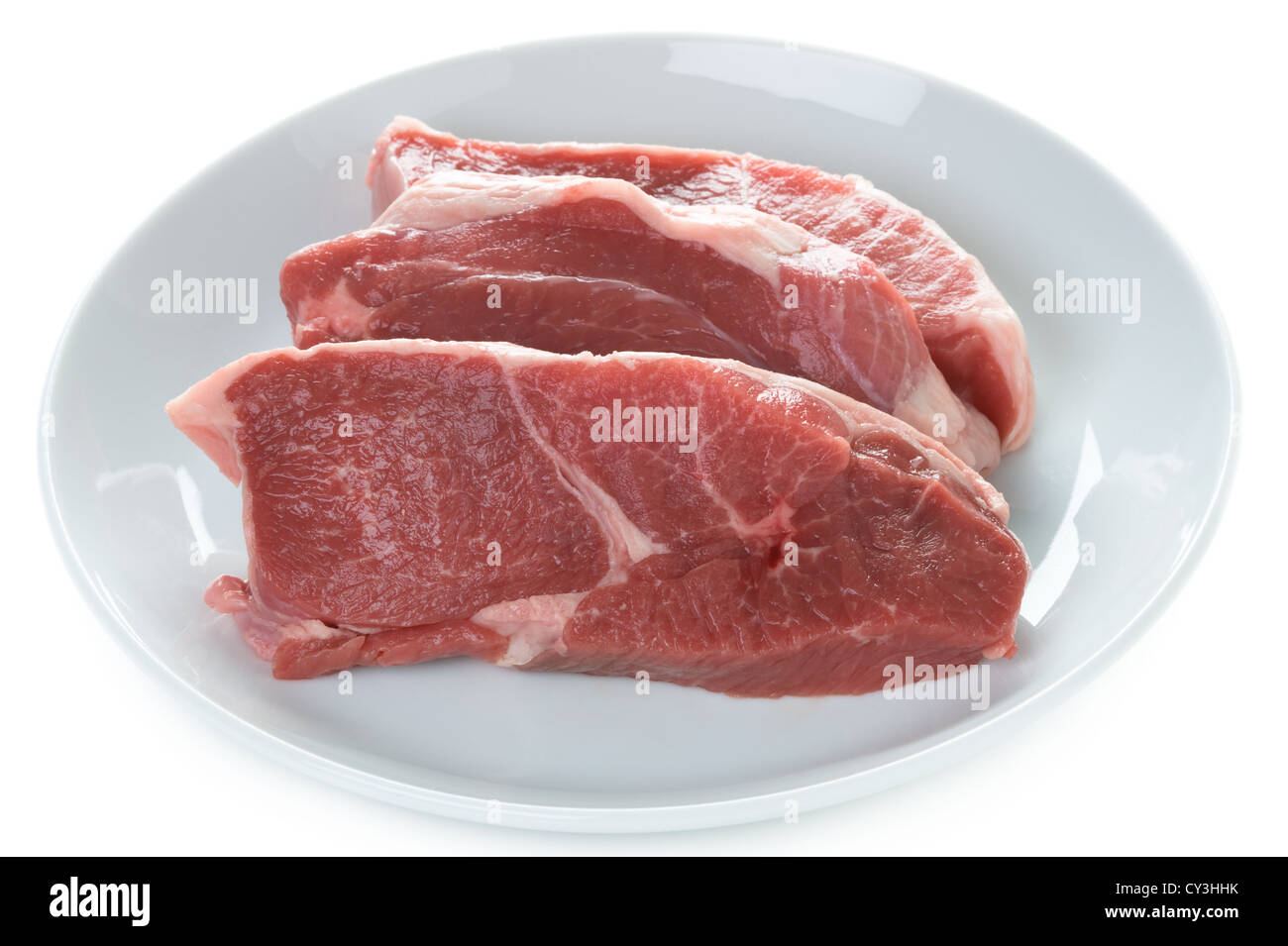 Raw gamba Di agnello bistecche di carne cruda su una piastra isolata su uno sfondo bianco Foto Stock