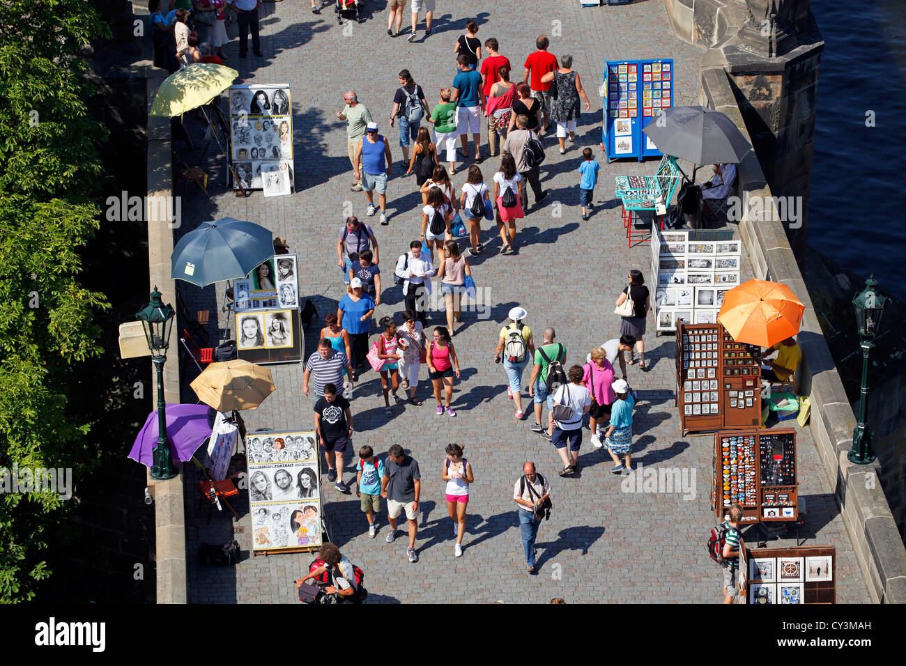 La folla di turisti e le bancarelle che vendono souvenir sul Ponte Carlo a Praga, Repubblica Ceca Foto Stock