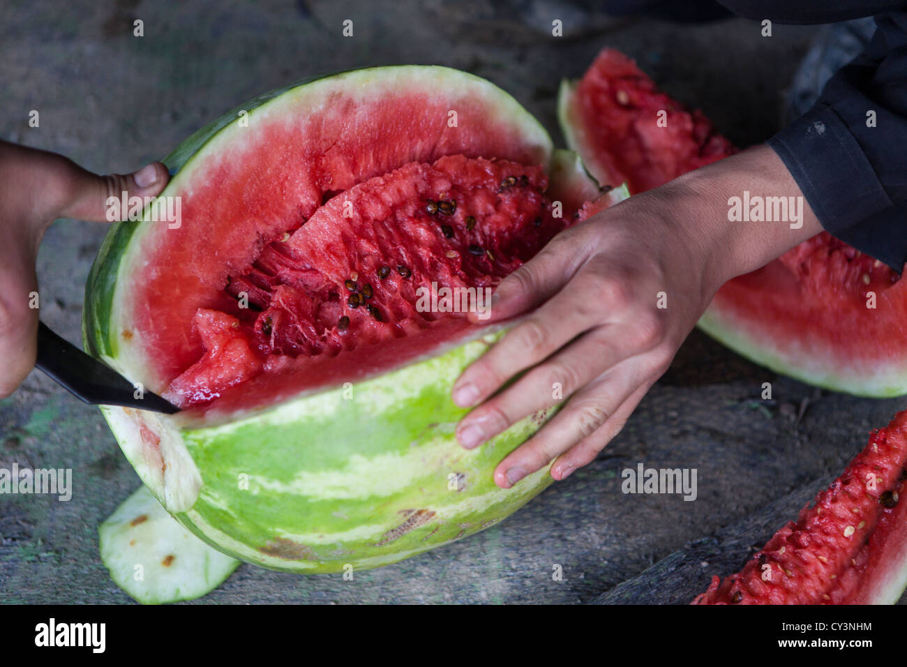 Gli afgani di mangiare un acqua-melone Foto Stock
