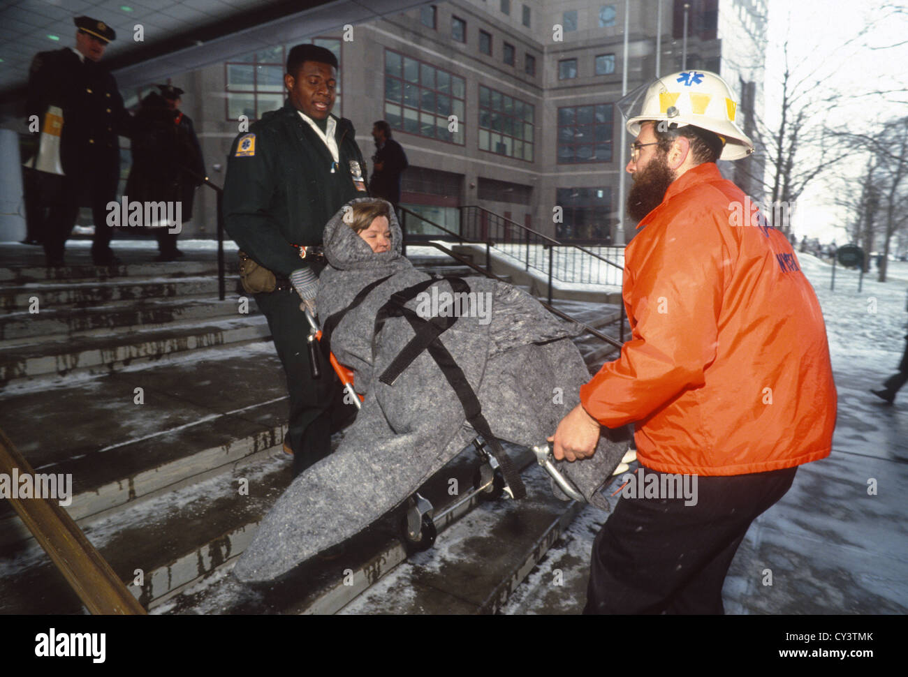 Primi responder evacuare i lavoratori, attraverso la neve e il ghiaccio in caduta dopo il bombardamento del World Trade Center Foto Stock