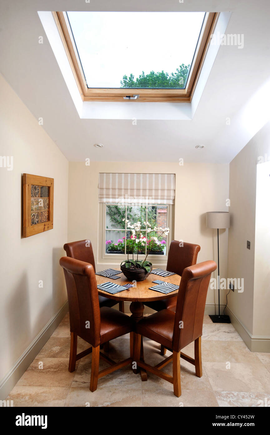 Una piccola sala da pranzo illuminata con luce naturale da un soffitto Velux finestra Foto Stock