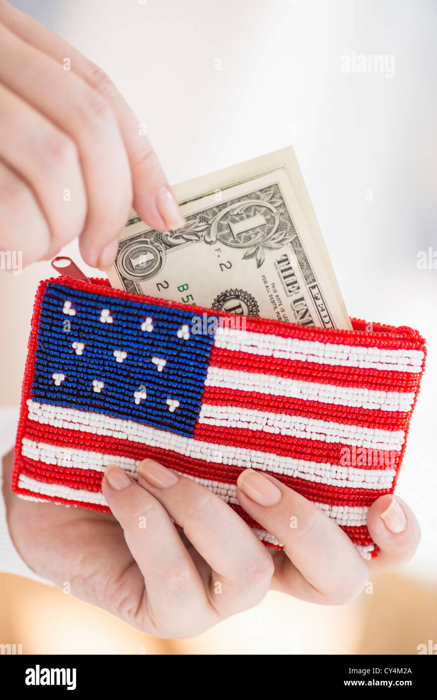 Stati Uniti d'America, New Jersey, Jersey City, Donna tenendo le banconote e portamonete con bandiera americana su di esso Foto Stock