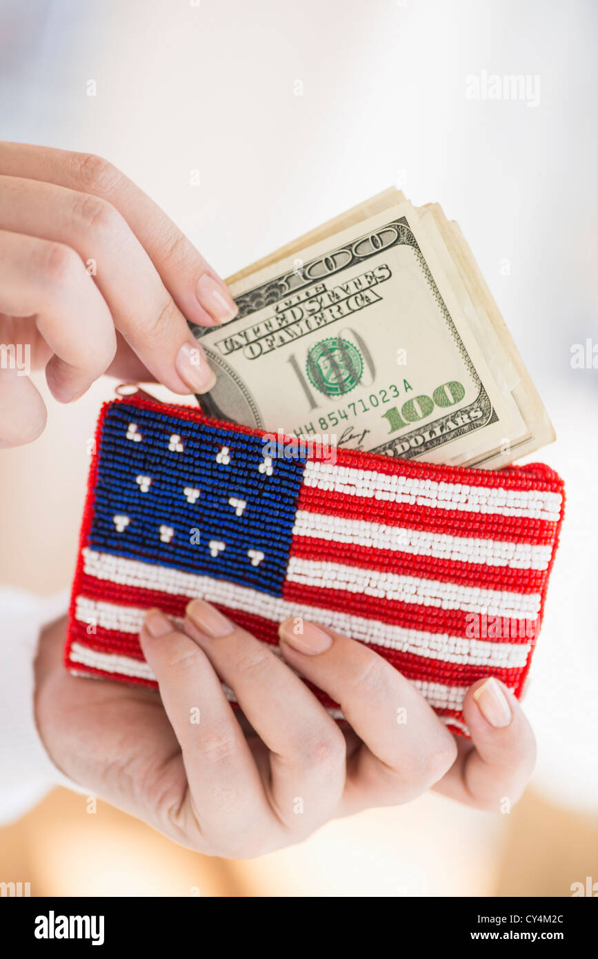 Stati Uniti d'America, New Jersey, Jersey City, Donna tenendo le banconote e portamonete con bandiera americana su di esso Foto Stock