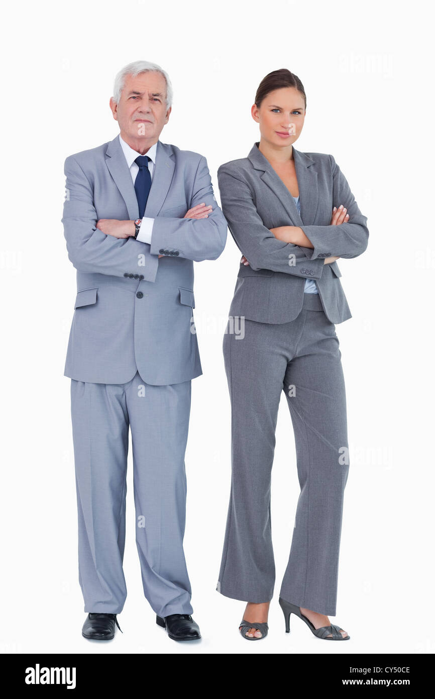 Imprenditore maturo e collega con i bracci ripiegati Foto Stock