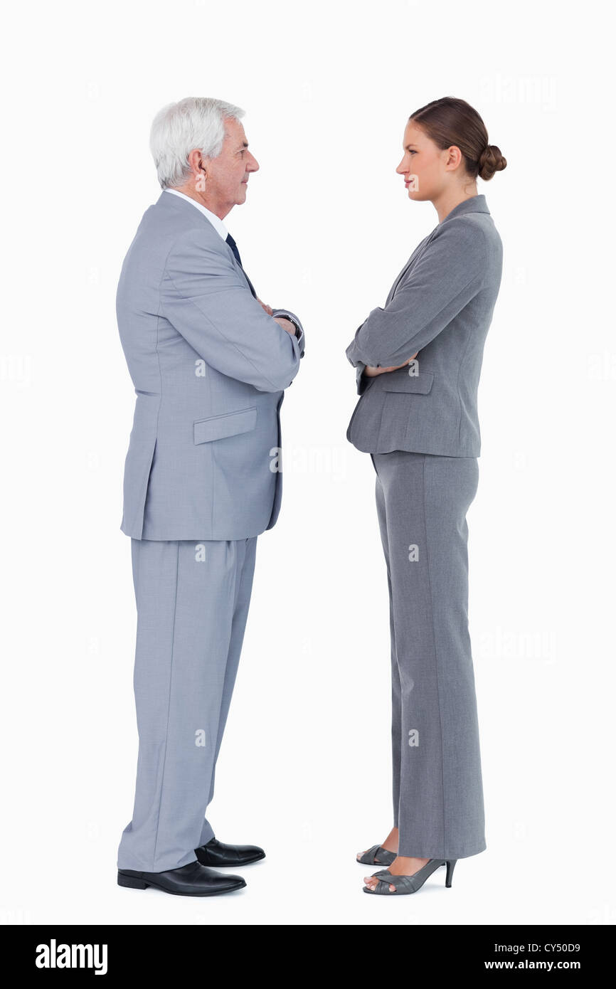 Businesspartner in piedi faccia a faccia con i bracci ripiegati Foto Stock