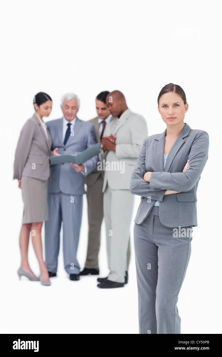 Tradeswoman con bracci ripiegati e colleghi dietro di lei Foto Stock