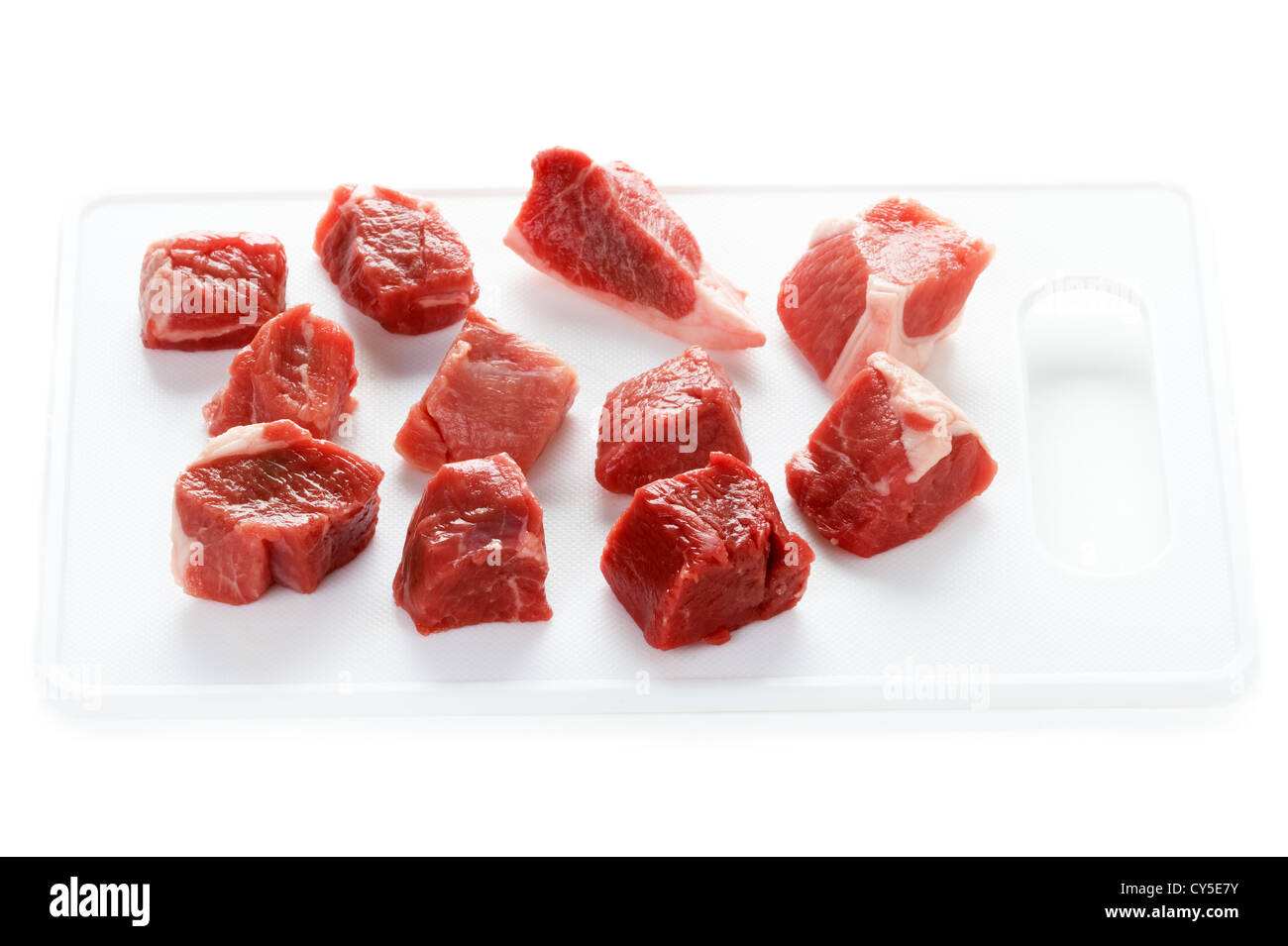 Tagliate a dadini materie carne di agnello tagliato a cubetti isolati su sfondo bianco Foto Stock