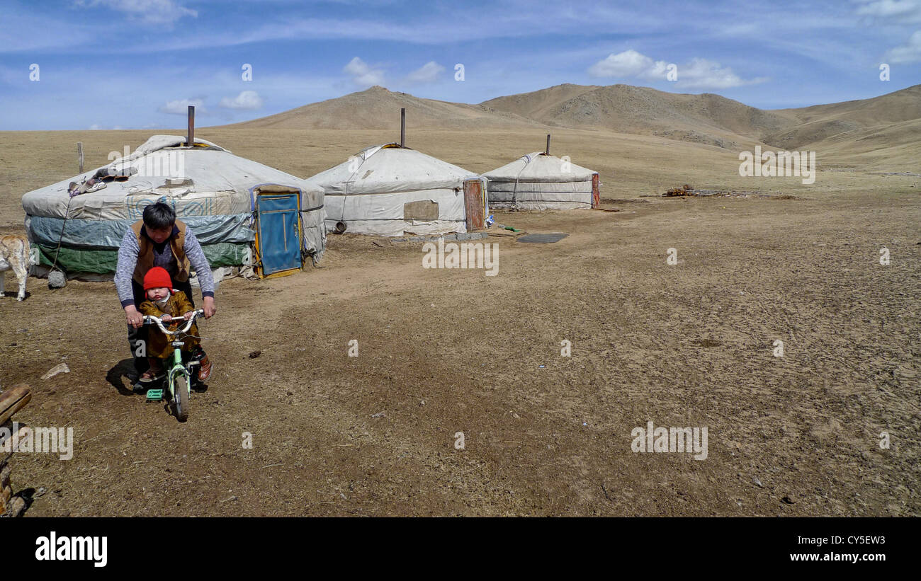 Un padre spingendo il suo figlio su una bicicletta. La foto è stata scattata in Mongolia. Foto Stock