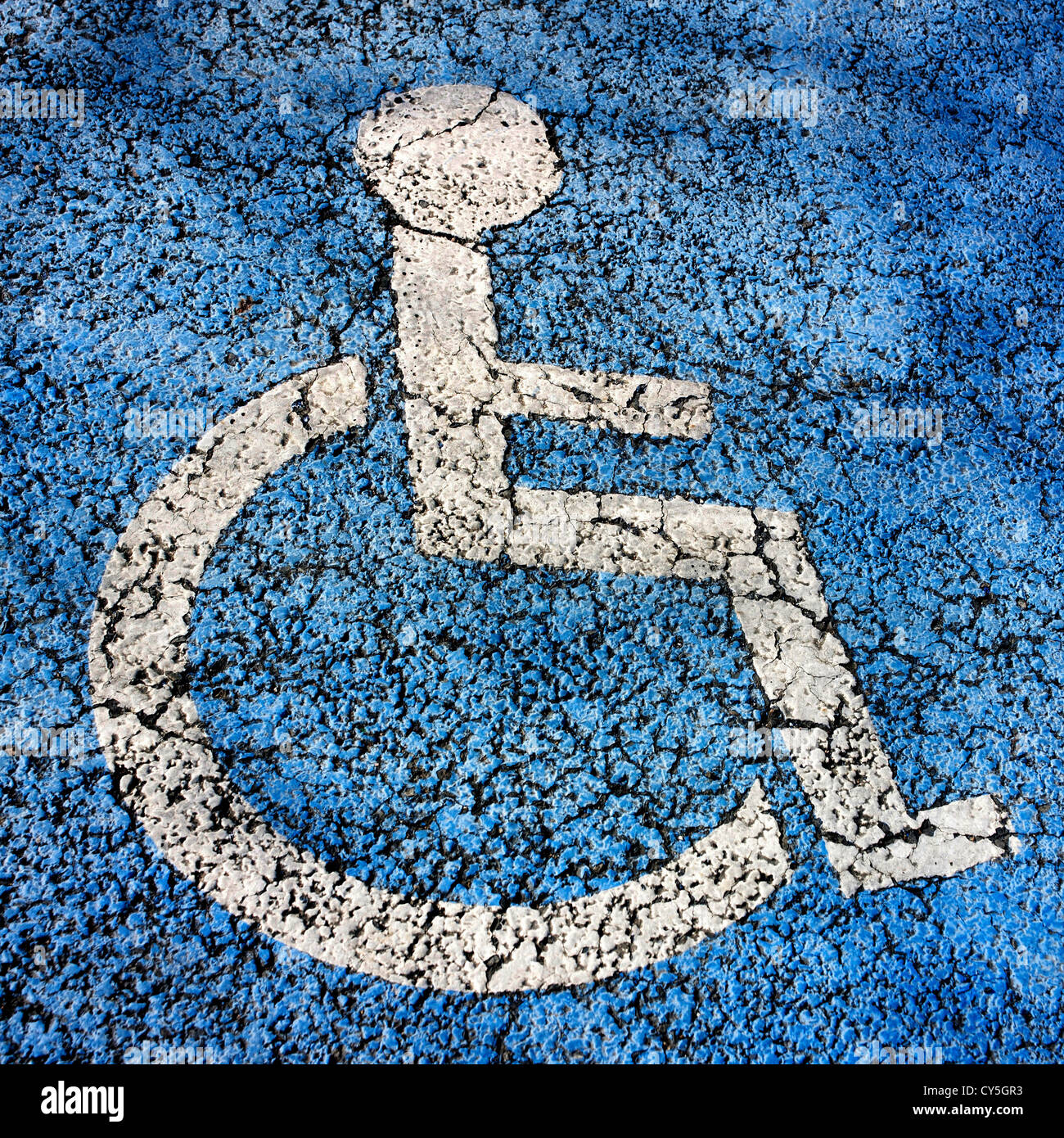 Simbolo di accessibilità su una superficie blu dello spazio di parcheggio che indica il parcheggio riservato Foto Stock