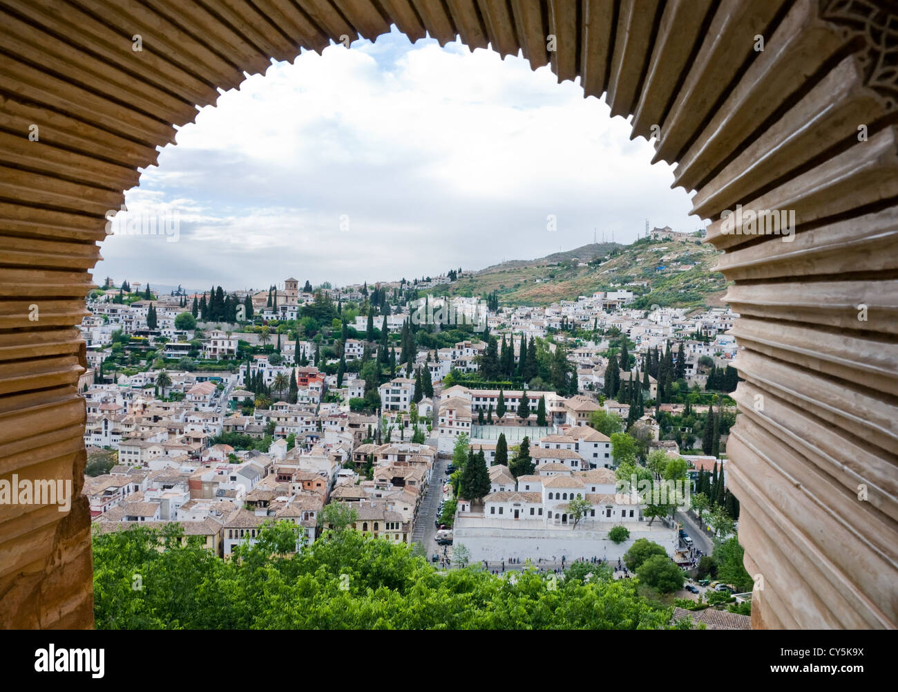 Una veduta aerea di case bianche di Granada Andalusia attraverso una finestra ad arco da Alhambra Palace Foto Stock